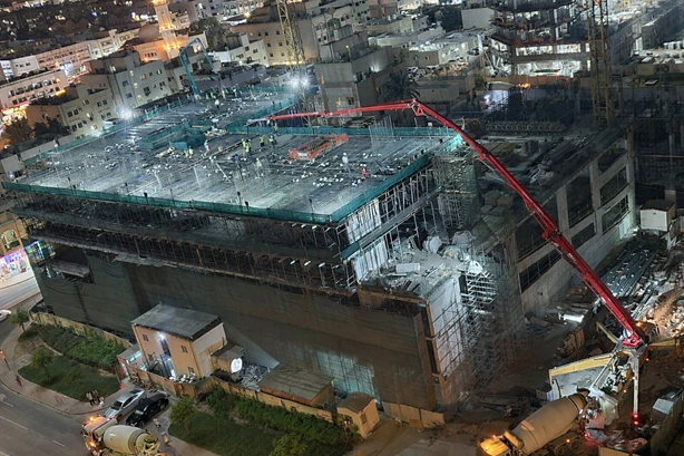 Concrete slab casting in a high-rise tower with reinforcement steel and construction workers during floor slab concreting