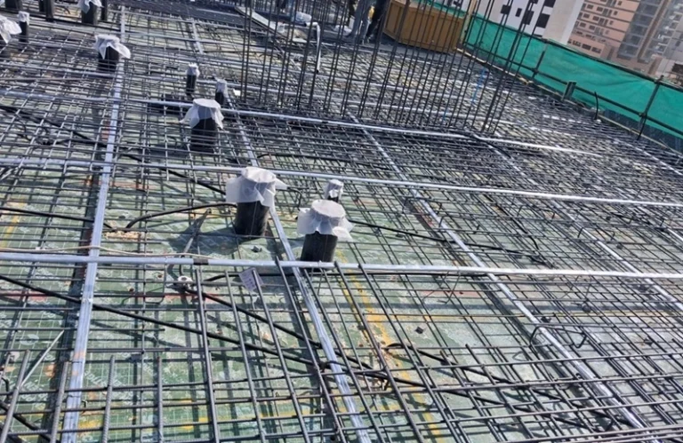 Workers installing reinforcement steel at a construction site using an optimized Bar Bending Schedule (BBS) to reduce steel wastage and improve installation efficiency.